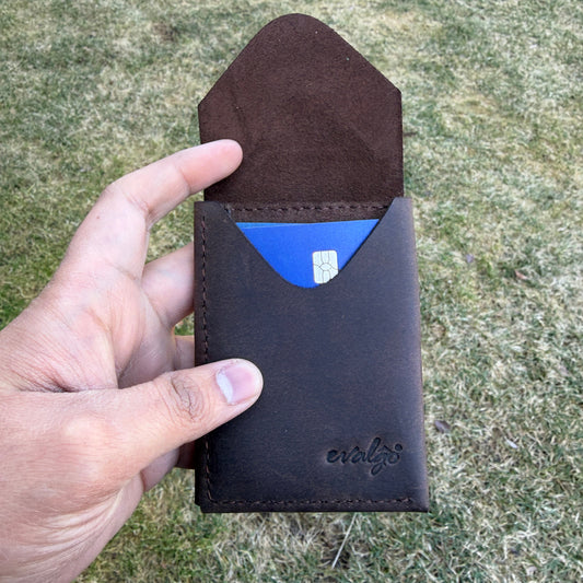 Hand holding a brown leather wallet